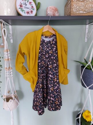 A mustard colour cocoon cardigan over a navy floral dress