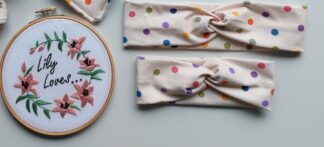 Two headbands, one adult size and one toddler, in a spotty Smarties design